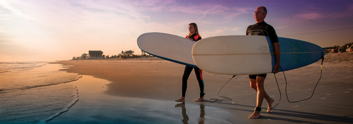 couple holding surf boards