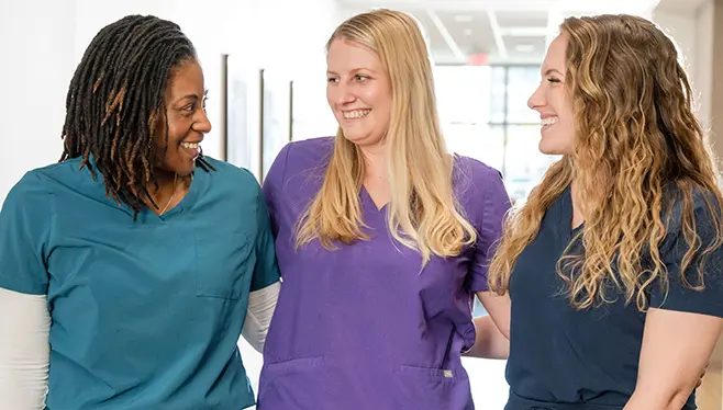 Three nurses interlocking arms